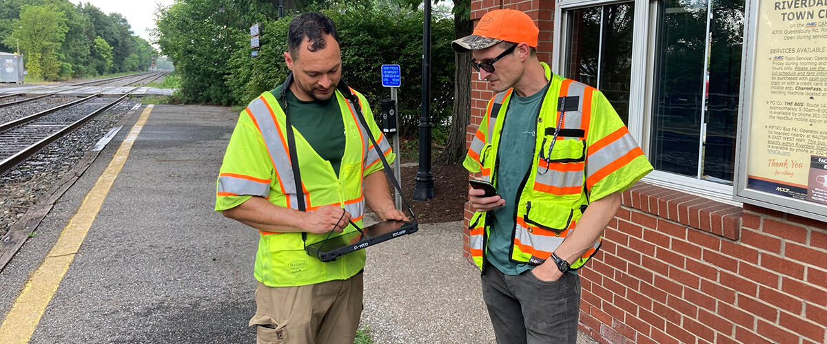 Workers surveying near railroad