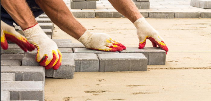 men adding pavers to the path