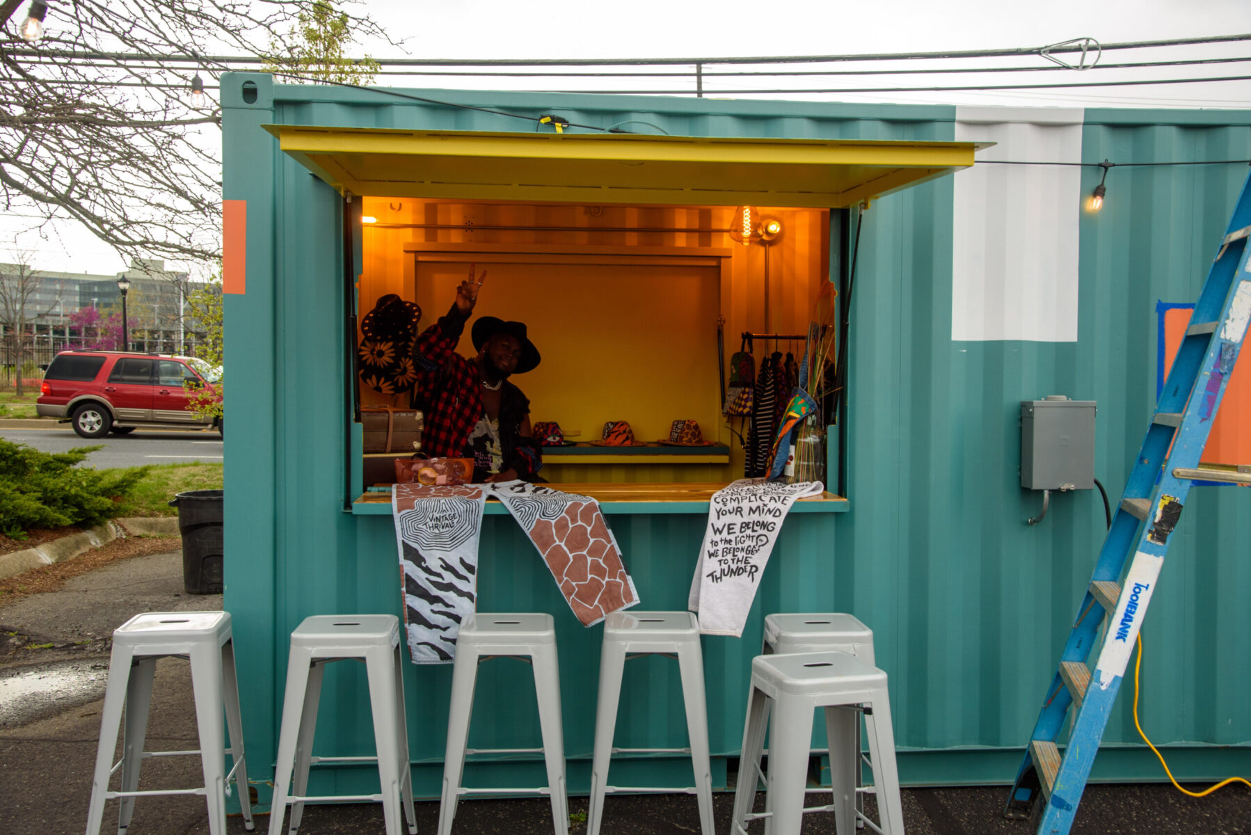 Small shop out of colorful storage unit run by a black man.