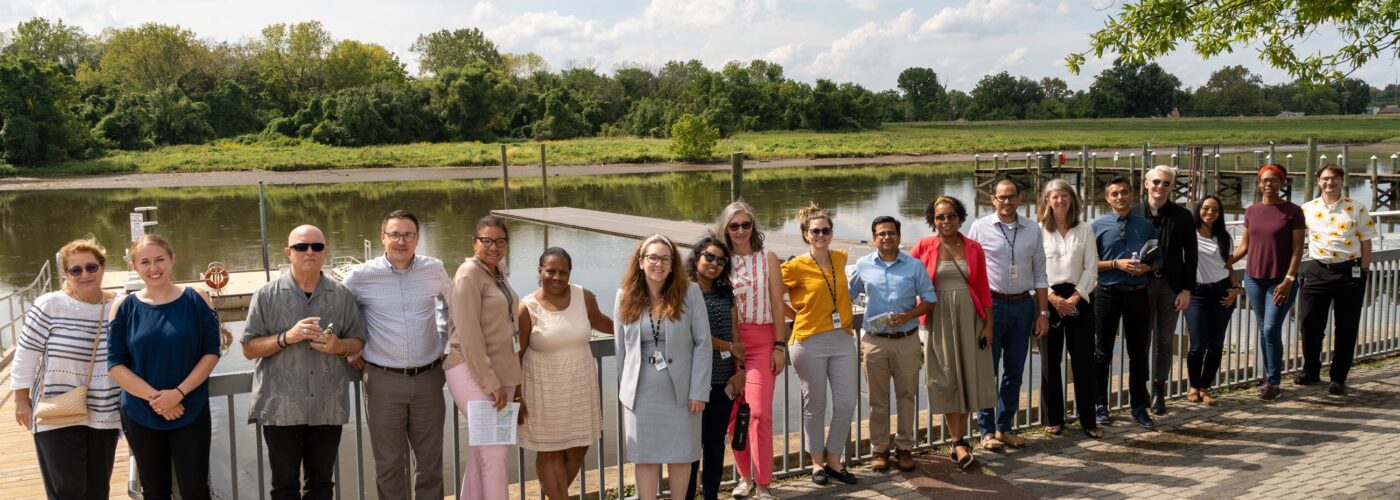 group poses in front of river