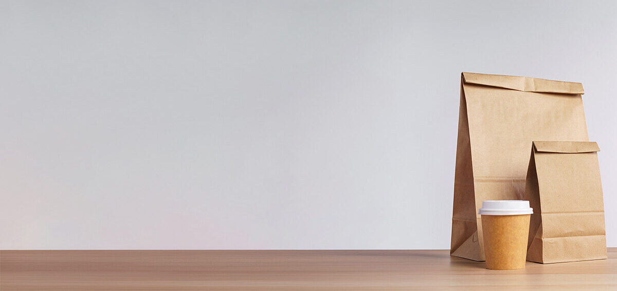Brown lunch bags on a grey table.